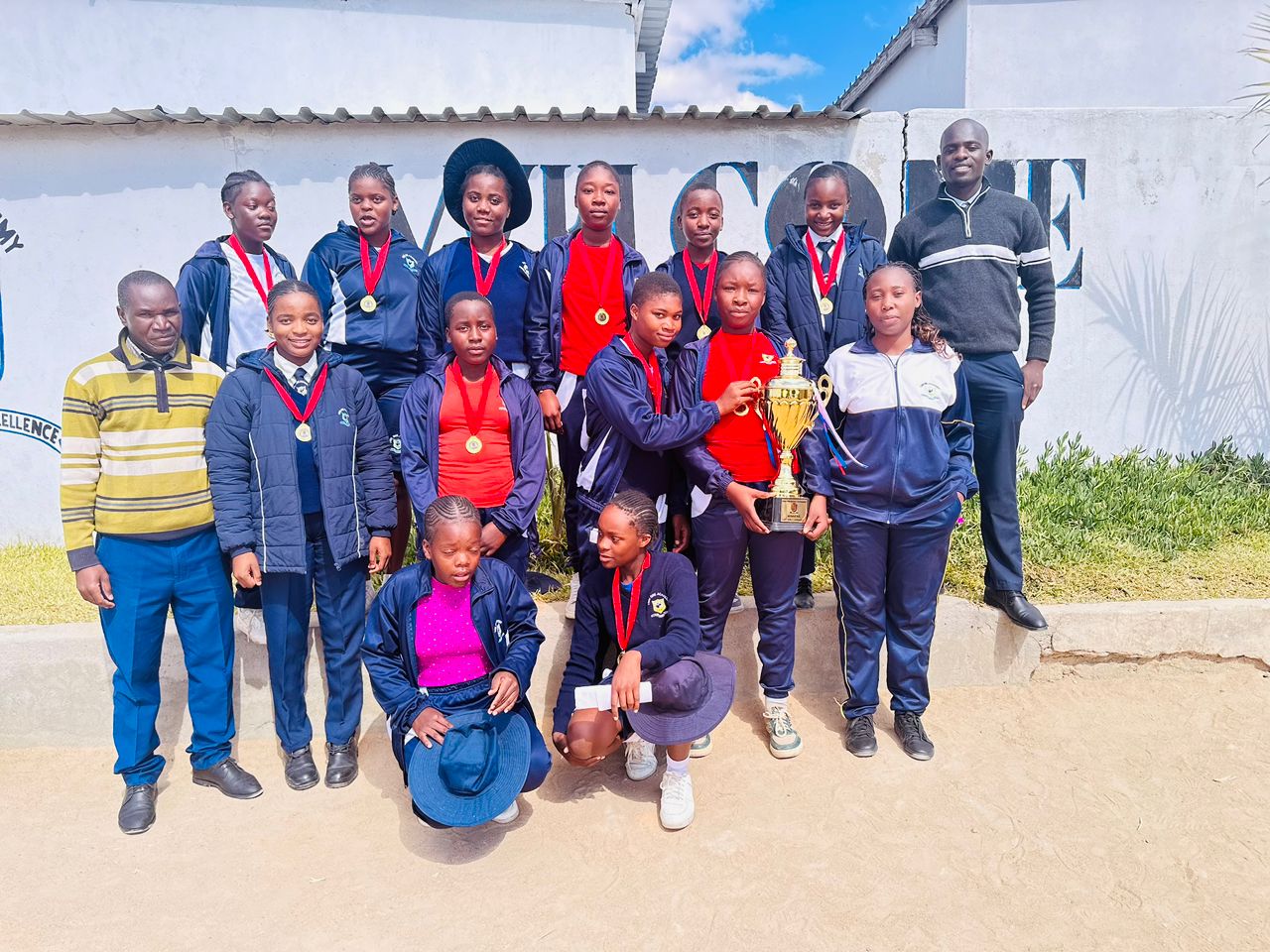 Twin One Academy students wearing sports medals with staff