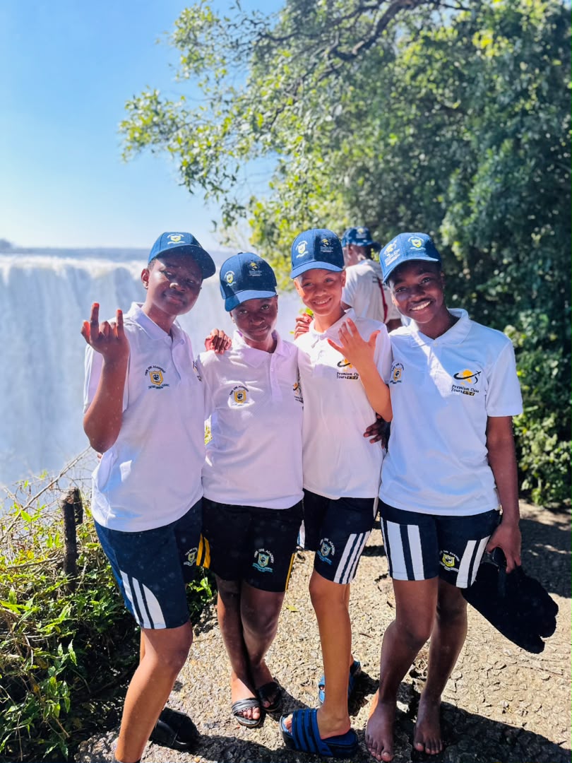 Learners smiling near the Victoria Falls waterfall