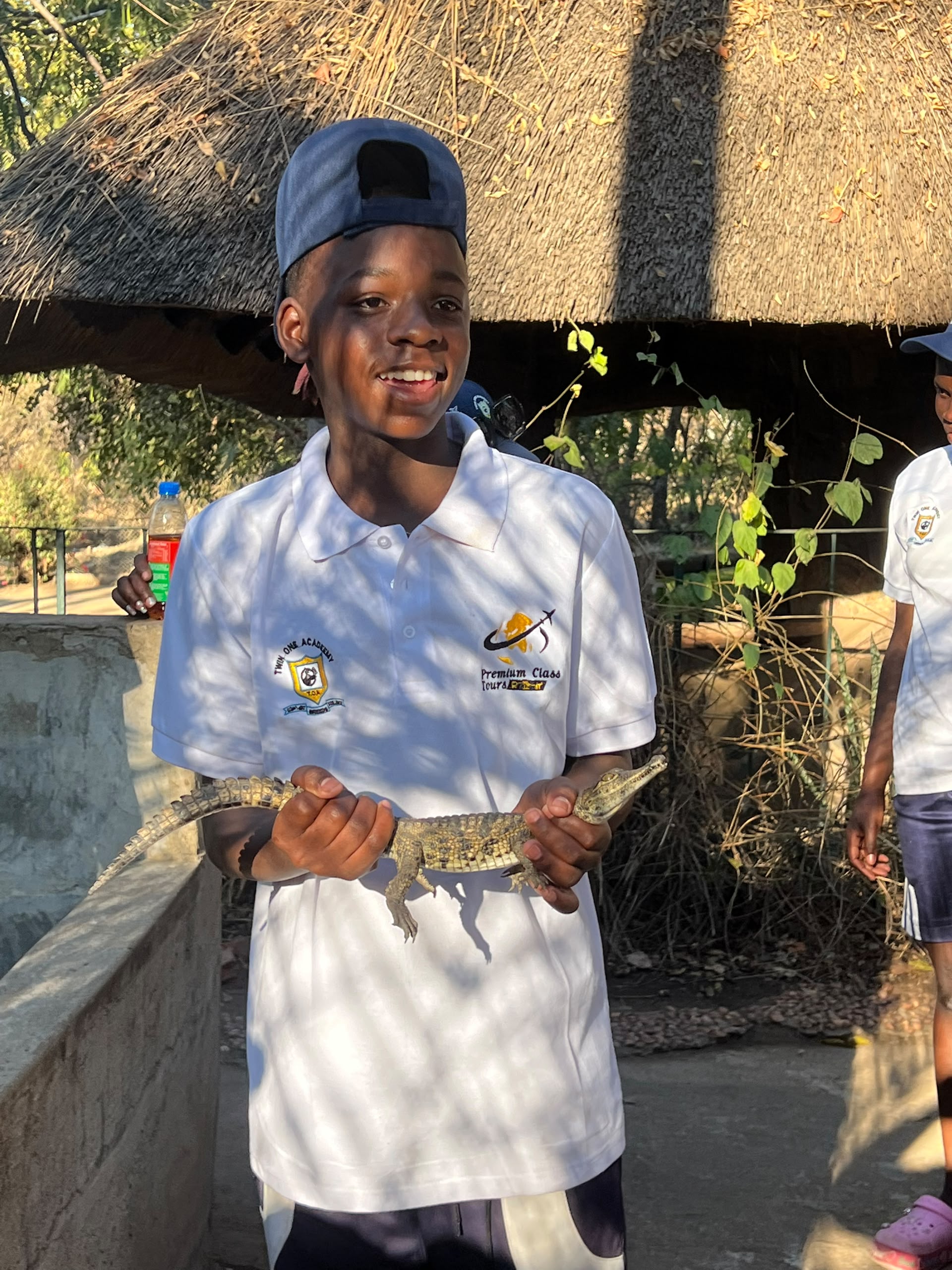 A learner holding a small crocodile during a wildlife learning activity
